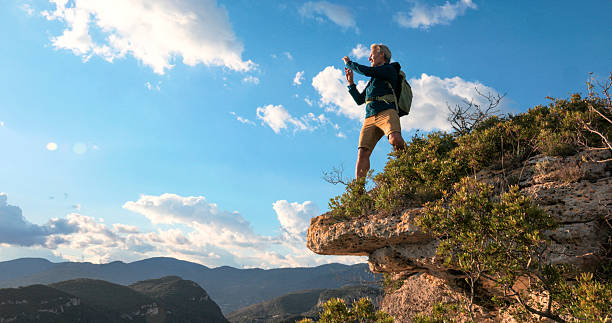 istock Hiker uses mobile phone on edge of mountain, Liguria 2212265543