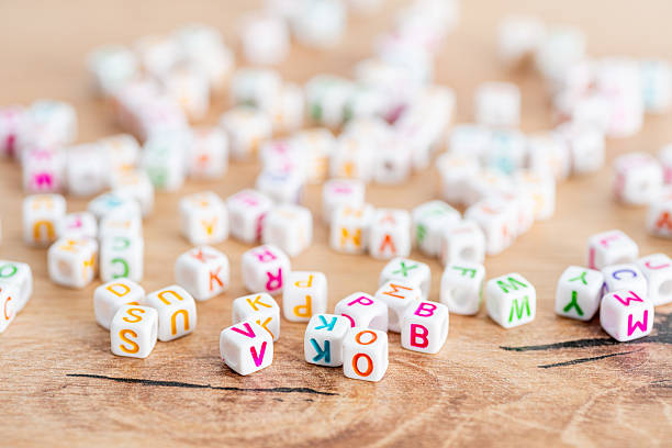 istock Scattered multicolor alphabet cubes on wood background 2212265723