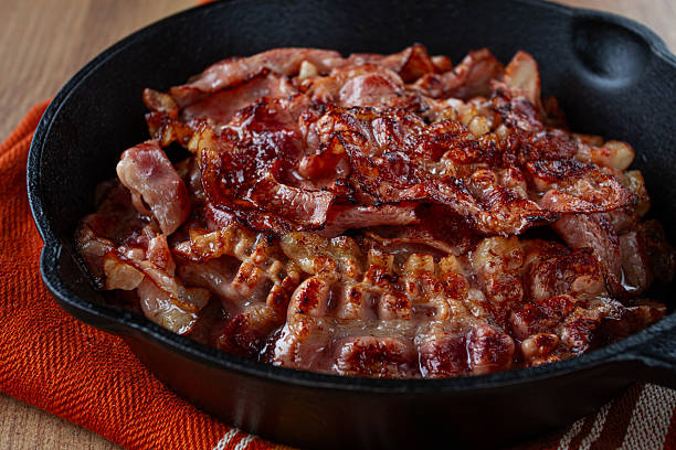 istock Crispy bacon, on a cast-iron skillet, on a wooden table, rustic style, no people 2212271995