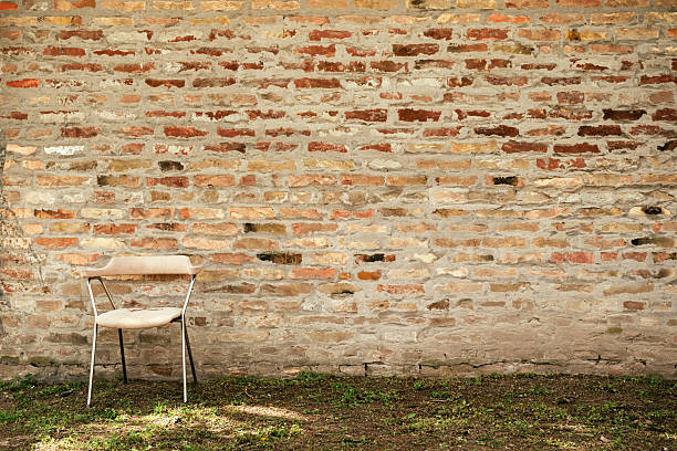 istock Empty chair seat against brick wall 2212273946