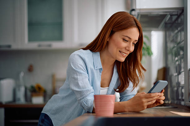 istock Happy woman using mobile phone at home. 2212274174