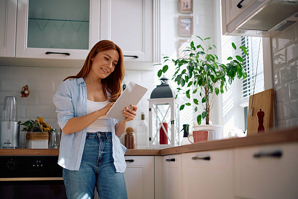 istock Happy woman using digital tablet in the kitchen. 2212274457