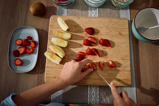 istock Above view of woman chopping fruit on cutting board. 2212274570