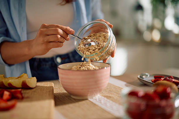 istock Close up of woman using oat flakes while making breakfast at home. 2212274575