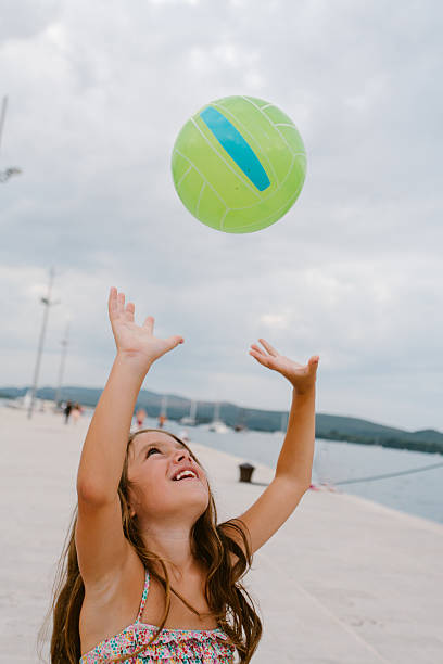 istock Young girl playing valleyball on the beach 2212277154