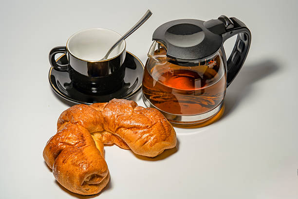 Black tea with pastries and a cup on a white background