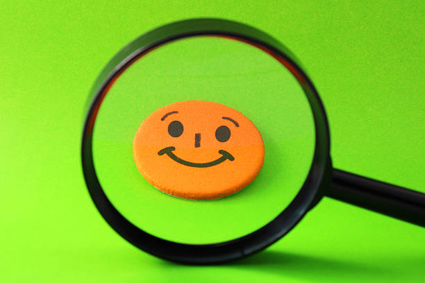 istock Magnifying glass selecting an orange happy face 2212284028