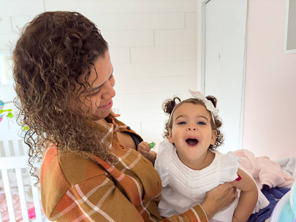 istock Adorable Toddler Making Funny Face While Mom Looks On with Love 2212285054