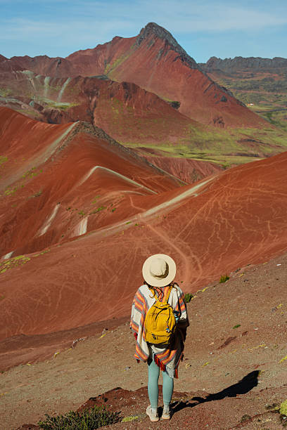 Woman looking at Vinicunca Rainbow mountain during trip to Peru