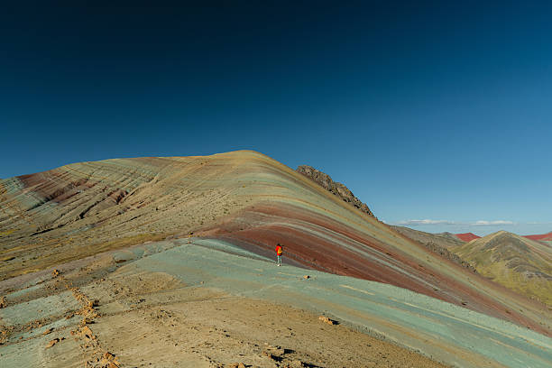 Woman hiking on rainbow mountain in Peruvian Andes