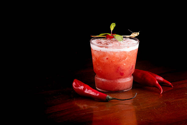 istock Spicy red cocktail with peppers and mint on pub table with black background 2212297567