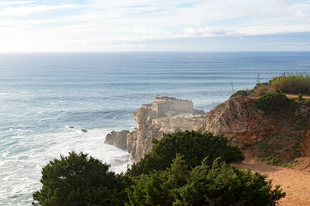 istock Scenic ocean view features a dramatic cliffside with a historic structure. Ideal for travel, adventure, and coastal lifestyle themes. Beautiful seascape backdrop. 2212305768
