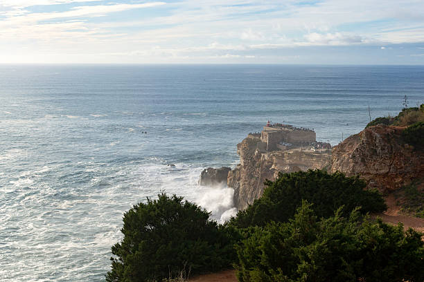 istock Dramatic coastal scene featuring a rocky cliff overlooking a vast ocean, waves crashing against the shore. Inspires travel, nature, and coastal themes. Perfect for backgrounds and ads. 2212305785