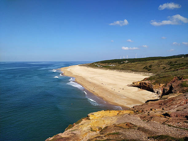 istock Scenic ocean view featuring golden sand beach, turquoise water, and rugged cliffs under a blue sky. Ideal for travel, nature, or coastal lifestyle themes. 2212305916