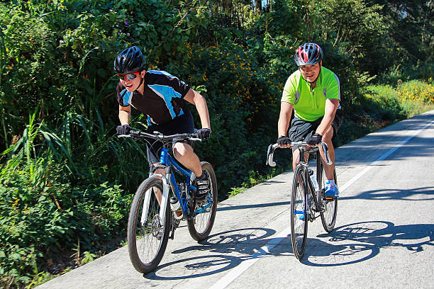 Man and woman on racing bicycles passing at Pistenende at Swiss village of Oberglatt on a sunny summer day. Photo taken July 12th, 2025, Zurich Oberglatt, Switzerland.
