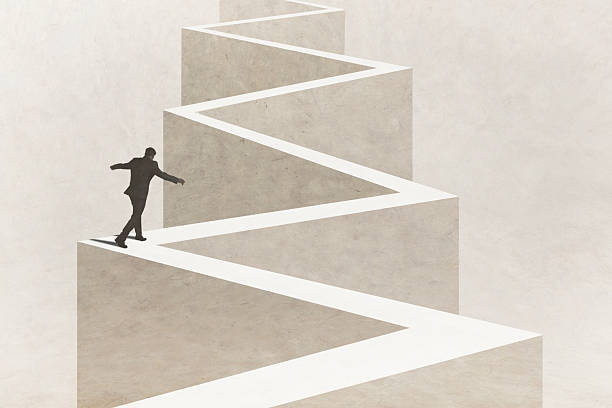 istock Man Walks Carefully On Top Of Jagged Path 2212315363