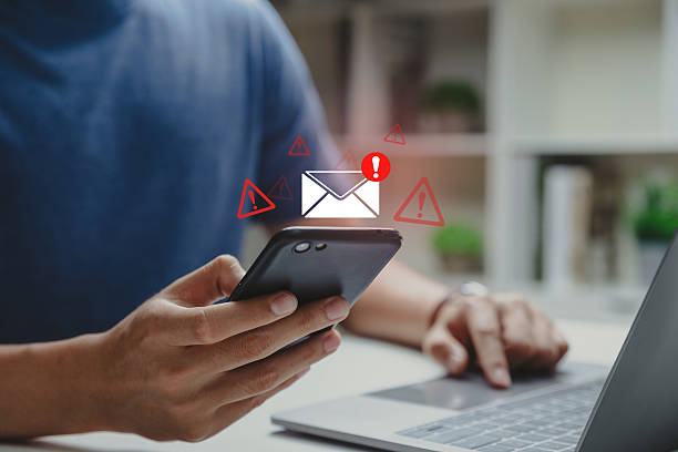 istock Young man using phone with email inbox alert and spam virus with warning. 2212317589
