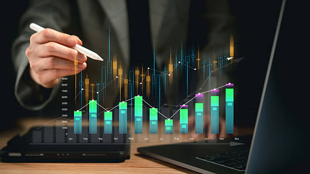 istock Close up of hand with stylus interacting with digital chart showing colorful graphs and data bars indicating financial analysis trends 2212319422