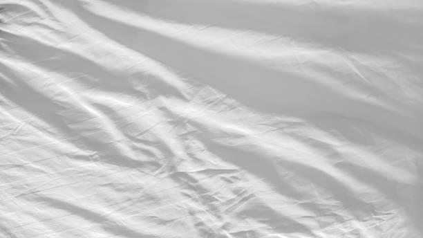 istock White and wrinkled bed sheet wave background. close up wave fabric. 2212320223