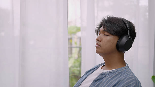 istock Young Asian Man Resting and drinking coffee in Cozy Quiet Space with Natural Light. 4k 2212321595