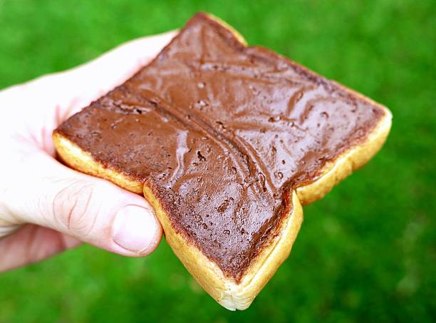 Eating Chocolate spread on slice of bread.