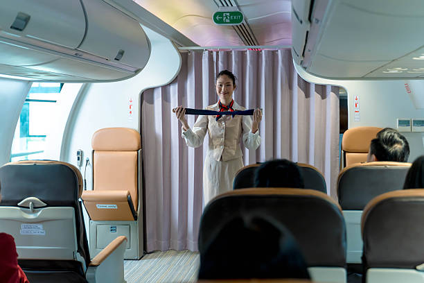 istock Flight attendant demonstrating seatbelt usage during in-flight safety instructions to passengers inside aircraft cabin before takeoff on a commercial airline 2212325417
