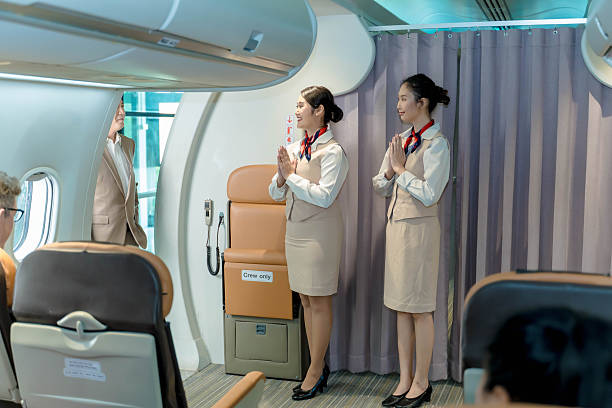 istock Flight attendants greeting passengers with traditional Thai wai gesture while welcoming onboard a commercial aircraft cabin before departure 2212325442