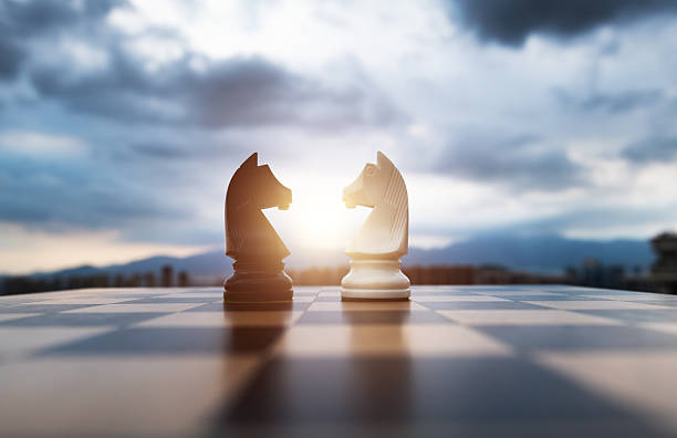 istock Two chess knights on city background 2212325790