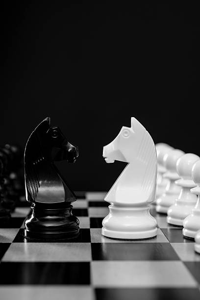 istock Two chess knights battle on black background 2212325798