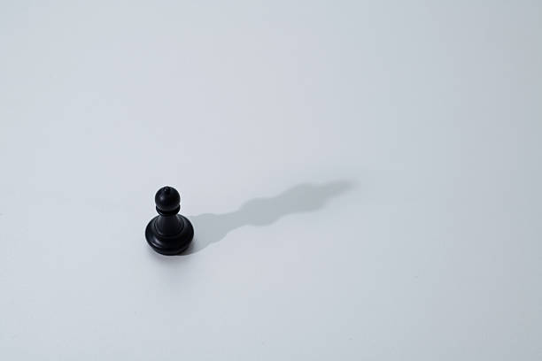 Black rook chess piece, figure isolated on white, object cut out, closeup. Simple small shiny game piece, castle tower architecture, fortress, building symbol abstract, game of chess pieces