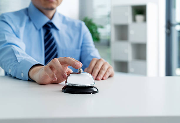 Businessman hand ringing a service bell.