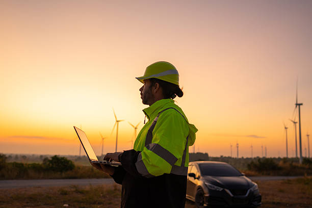 istock Engineer working on laptop checking wind turbines of the field. 2212328423