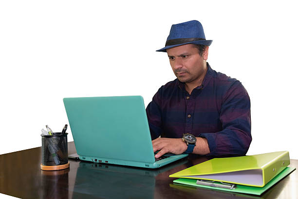 istock man in hat works on his laptop computer, white background 2212330768