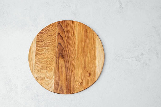 istock Circular wooden serving board placed on a neutral background for culinary use 2212334197