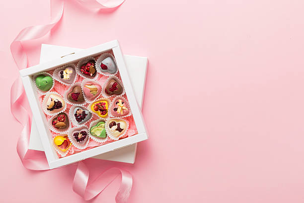 istock Holiday composition: sweet candy, with gift boxes with bow and chocolate hearts, photo template, background. Top View with copy space on colored background 2212335210