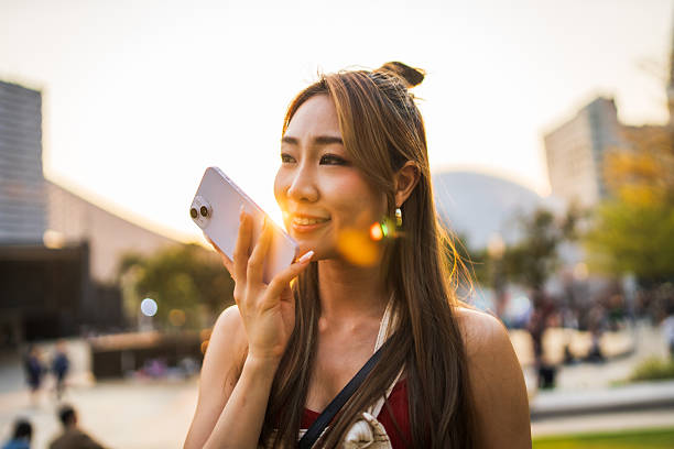 istock Modern communication, woman records audio while strolling in city. 2212335404