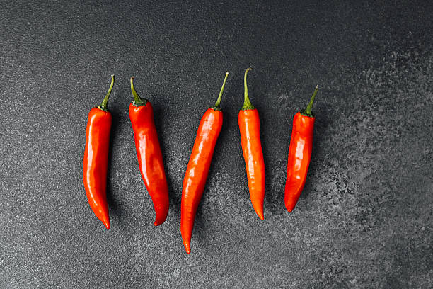 istock Fresh red chili peppers arranged on a dark surface for culinary preparation 2212336070