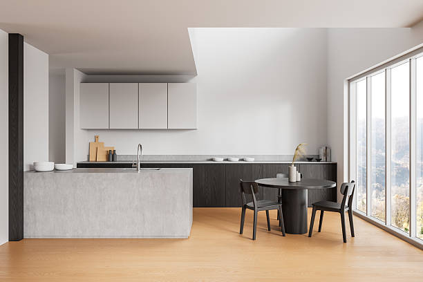 istock Modern minimalist kitchen interior with dining area, large windows, sleek cabinetry, and natural wood flooring in bright daylight ambiance. 3D Rendering 2212337158