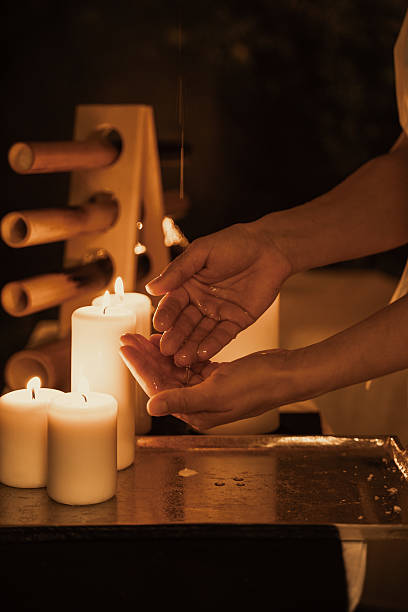 istock Hands Receiving Warm Oil Next to Lit Candles 2212337431
