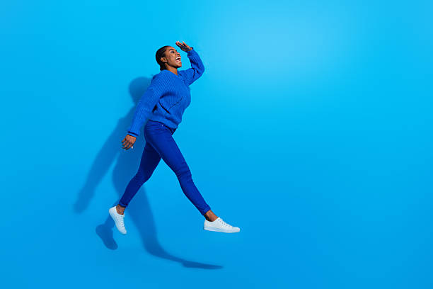 istock Photo of excited dreamy lady dressed pullover jumping looking far away empty space isolated blue color background 2212338280