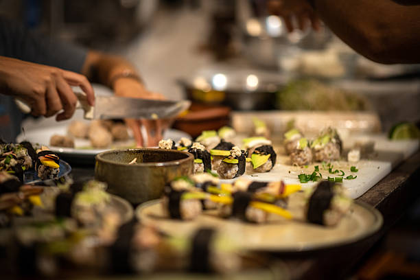 Chefs Preparing Sushi Rolls in a Busy Kitchen
