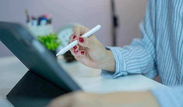 istock Close up woman hand using stylus pen drawing on digital tablet, creative working at home office with modern technology and comfortable environment 2212340633