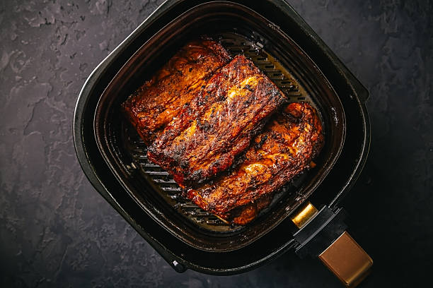 istock Preparing juicy spare ribs with airfryier, BBQ meat 2212340709