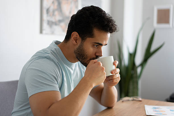 istock Young adult man drinking coffee or tea at home 2212341179