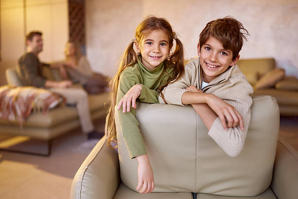 istock Happy siblings relaxing on sofa in the living room. 2212341277