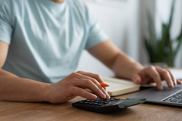istock Accountant calculating budget using calculator and laptop in office 2212341383