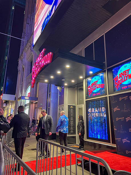 Guests arriving at Planet Hollywood during a grand opening event. Red carpet lined with security guards. Vibrant nightlife and exclusive celebrations.