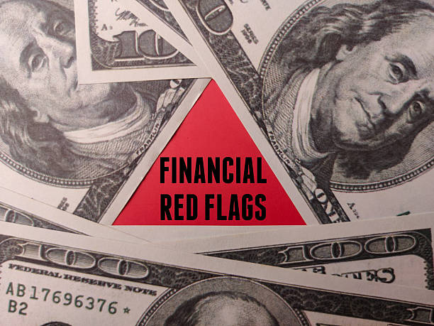 The red triangle with word FINANCIAL RED FLAGS on a hundred dollars.