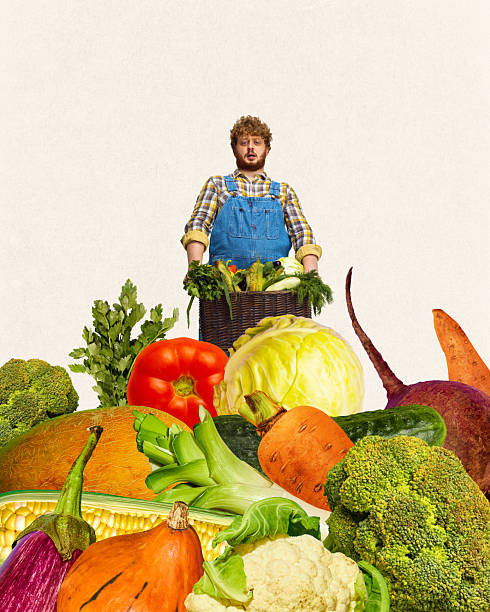 istock Farmer man standing with basket surrounded by fresh colorful vegetables against neutral background. Organic vegetables produce. 2212343204