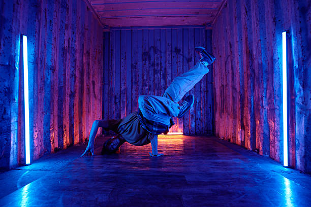 Young fit man in jeans performing a one hand stand isolated on white background